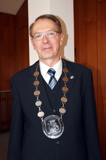 Johannes Masseling, Vorsitzender des Heimat- und Verkehrsvereins Weeze, präsentiert stolz die neue Kette, die er stellvertretend zum 60-jährigem Jubiläum erhalten hat